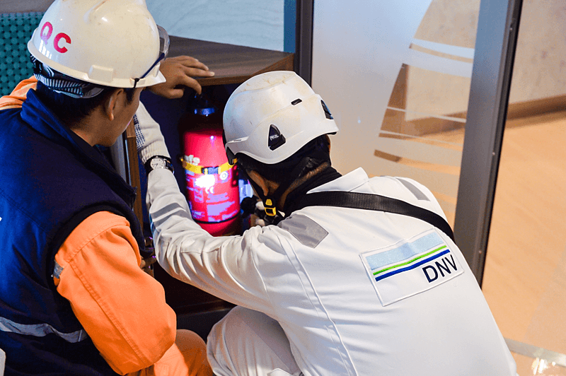 Pracownik DNV sprawdzający gaśnicę