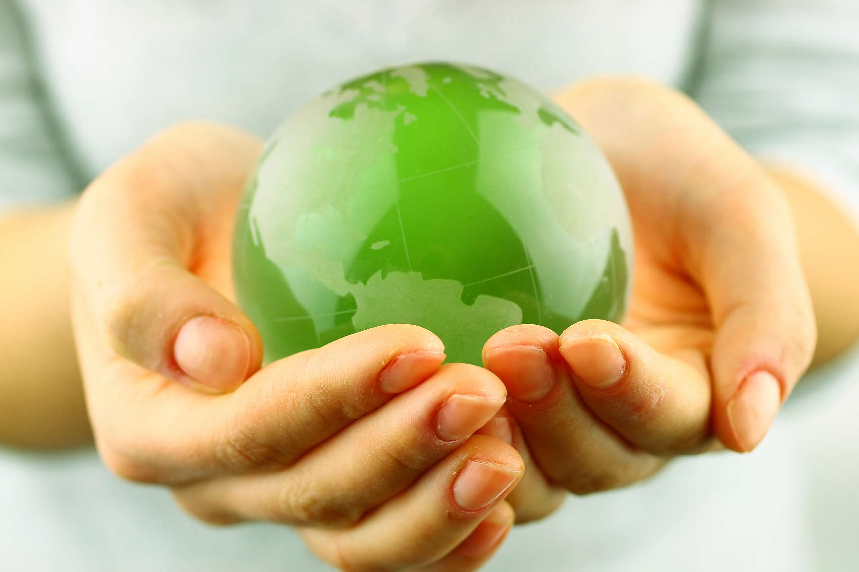 a small green globe in a woman's hands