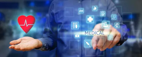 Dłoń trzymająca serce symbolizujące służbę zdrowia, ręka lekarza wybierająca placem na futurystycznym ekranie